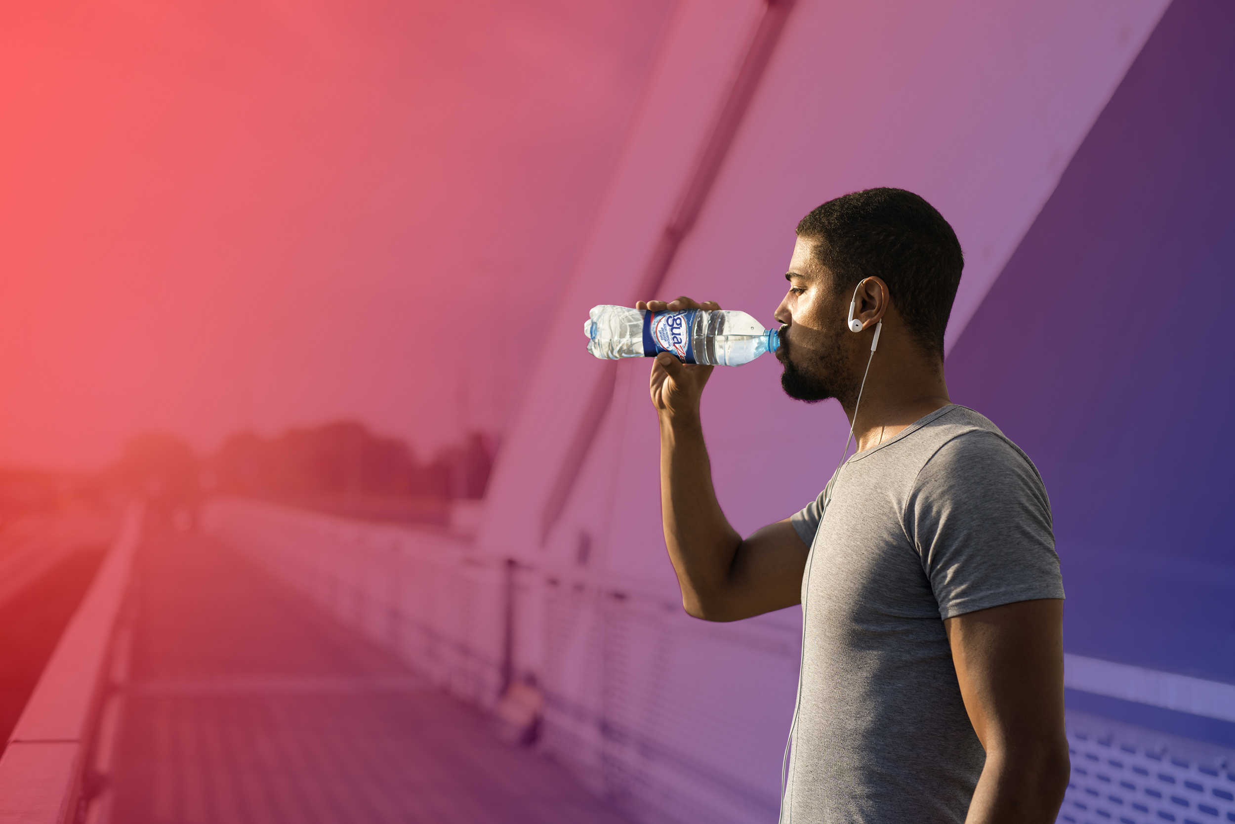 Attractive athlete holding bottle of water and drinking before training.